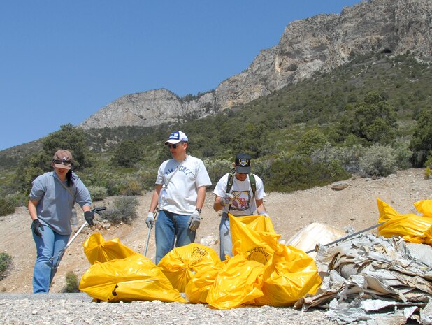 LAS VEGAS—From left to right, Staff Sgt. Katie Carter, 57th Operations Support Squadron; Master Sgt. David Clarke, 57th Operations Group; and Master Sgt. Daniel Warzynak, 505th Operations Group, all from Nellis AFB, Nev., bag trash at a collection point during the Spring Mountain Cleanup May 10. Volunteers clear trash and debris from campsites, roadways and trails from Spring Mountains National Recreation Area west of Las Vegas during the annual U.S. Forest Service sponsored event.  More than 40 Nellis and Creech AFB Airmen and family members took part in this year's event.  (U.S. Air Force photo/Chief Master Sgt. Gary Emery)