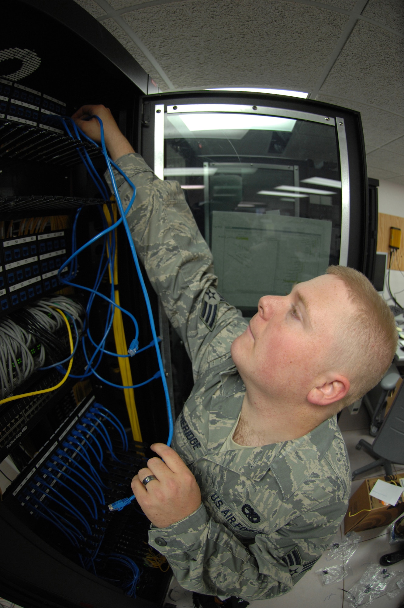 Senior Airman Etheridge, plugs in Cat-5 cable to the existing patch panel at Holloman Air Force Base, N.M. May 05. SrA Etheridge is an infrastructure technician assigned to the 49th Communications Squadron.
(U.S. Air Force photo/ Senior Airman Anthony Nelson Jr)  
