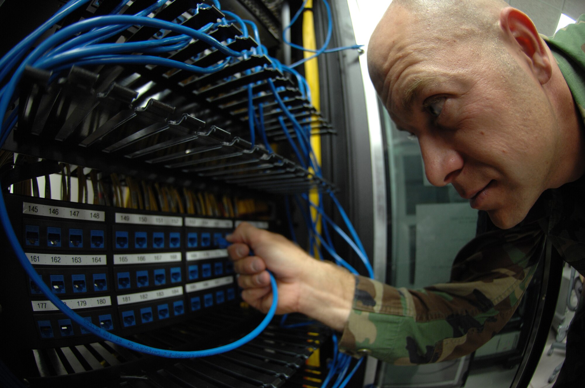 Staff Sergeant Eric Frazier, traces and organzies Cat-5 cable so it can be removed from the exsiting patch panel at Holloman Air Force Base, May 05. Sgt Frazier is assigned to the 49th Communications Squadron.
(U.S. Air Force photo/ Senior Airman Anthony Nelson Jr)  
