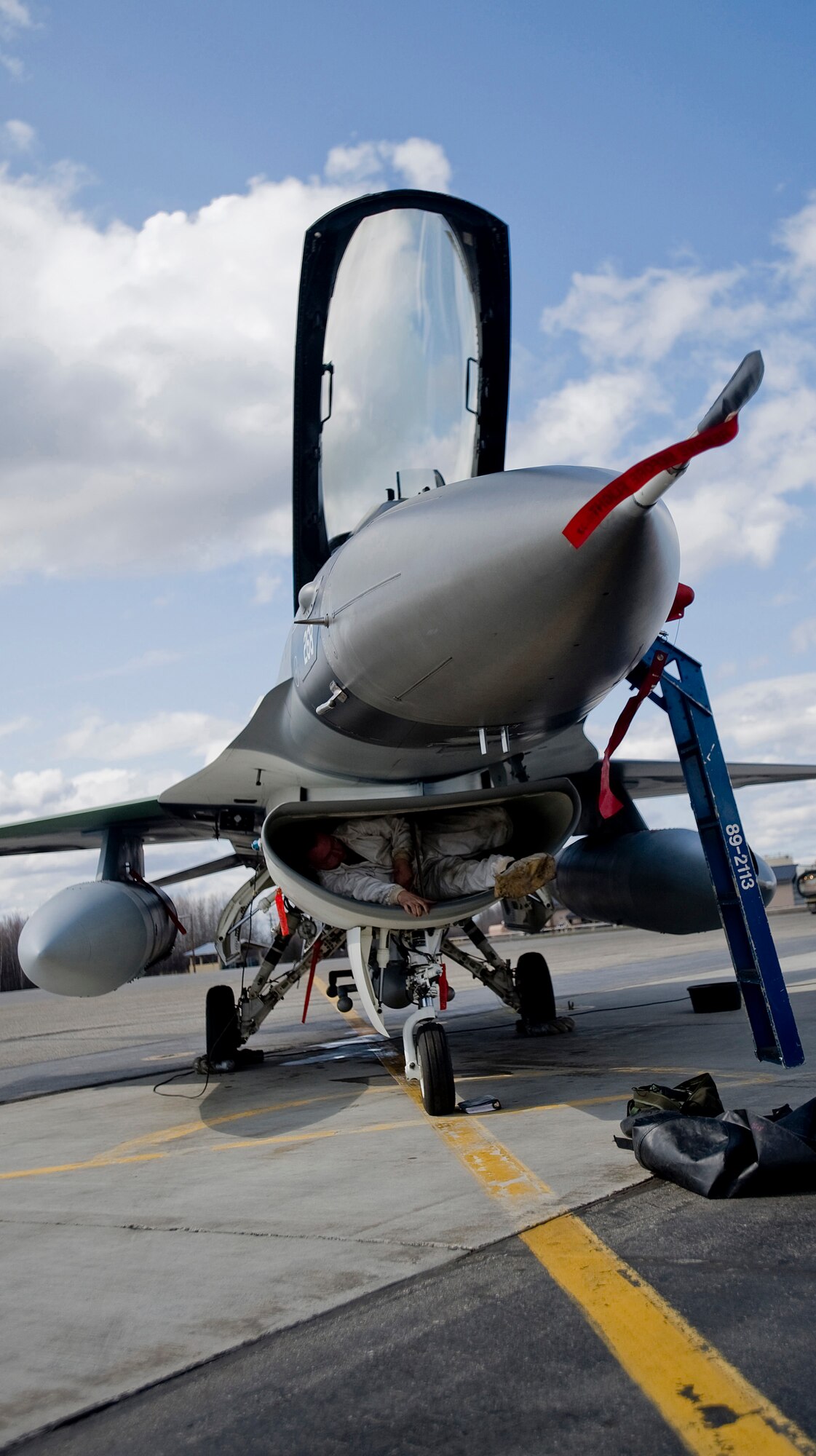 Staff Sergeant Dustin Stewart of the 354th Aircraft Maintenance Squadron, crawls out of  an F-16 intake at 18th Aggressor Squadron after checking fan blades for wear and tear at Eielson Air Force Base, Alaska on May 8, 2008. The 18th Aggressor Squadron is participating in Northern Edge, simulating enemy aircraft from various countries in order to allow joint forces to train for world wide crises. (U.S. Air Force Photo by Airman 1st Class Jonathan Steffen)
