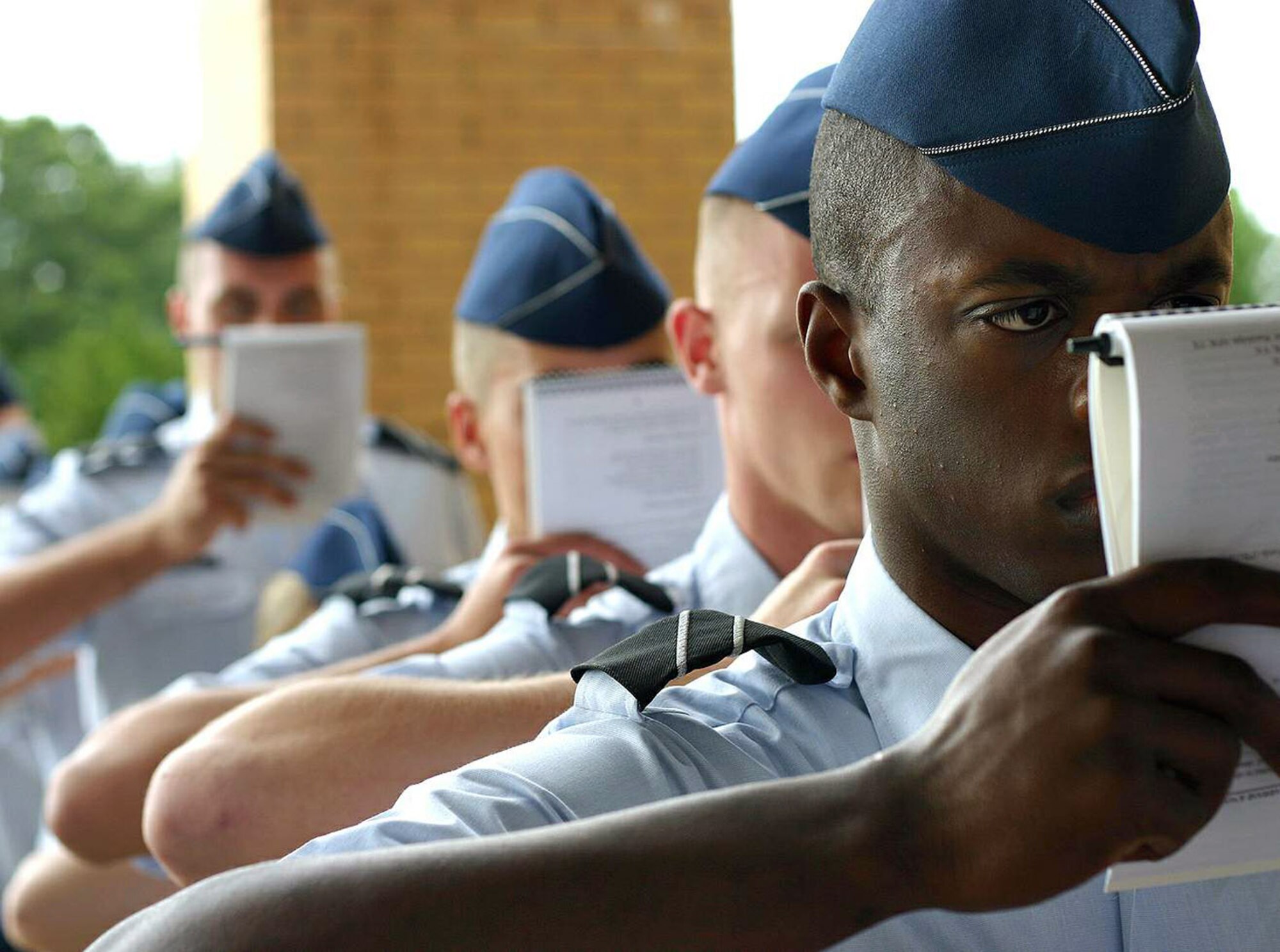 Cadet Tony Nelson (right) and other Air Force ROTC cadets study their training manuals while waiting to in-process summer field training May 8 at Maxwell Air Force Base, Ala. More than 360 ROTC cadets, mostly rising juniors from 144 colleges nationwide, started off the first class of summer field training. Cadet Nelson is from Det. 765, The Citadel -- The Military College of South Carolina. (U.S. Air Force photo/Staff Sgt. Jason Lake) 

