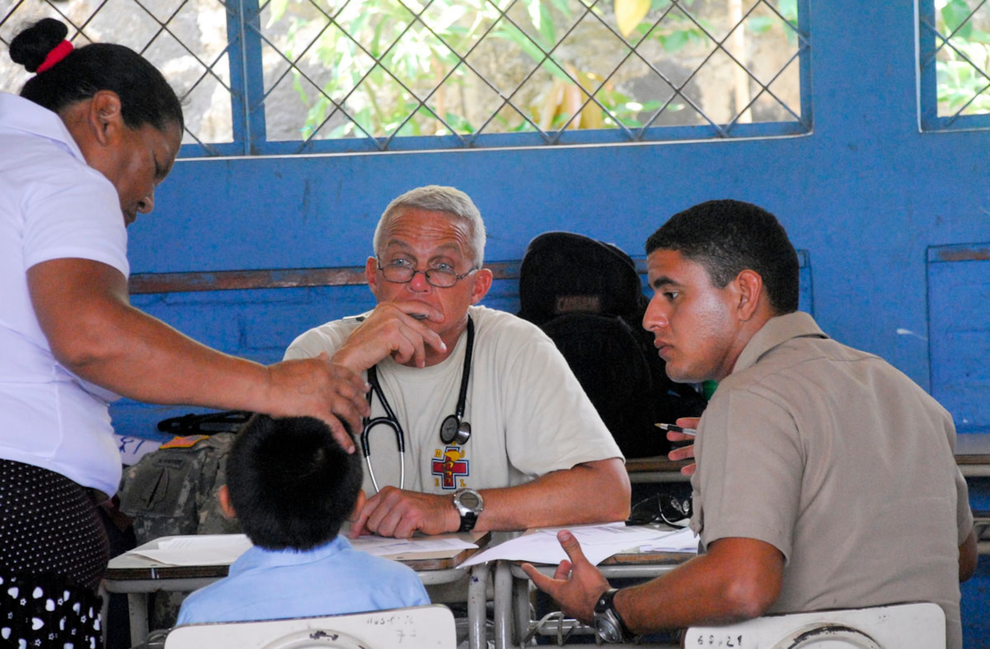 COMASAGUA, El Salvador ? Army Lt. Col. Mike Hoilien listens to an explanation of symptoms from the mother of a Salvadoran boy May 7. The medical personnel often relied on translators, like El Salvadoran navy ensign Pedro Rosales, to provide information during Fuerzas Aliadas Humanitarias 2008, the U.S. Southern Command and Salvadoran Ministry of Defense-sponsored exercise held throughout the Central American region May 5-15. (U.S. Air Force photo by Tech. Sgt. William Farrow)  