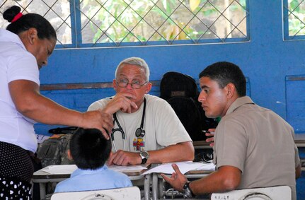 COMASAGUA, El Salvador ? Army Lt. Col. Mike Hoilien listens to an explanation of symptoms from the mother of a Salvadoran boy May 7. The medical personnel often relied on translators, like El Salvadoran navy ensign Pedro Rosales, to provide information during Fuerzas Aliadas Humanitarias 2008, the U.S. Southern Command and Salvadoran Ministry of Defense-sponsored exercise held throughout the Central American region May 5-15. (U.S. Air Force photo by Tech. Sgt. William Farrow)  