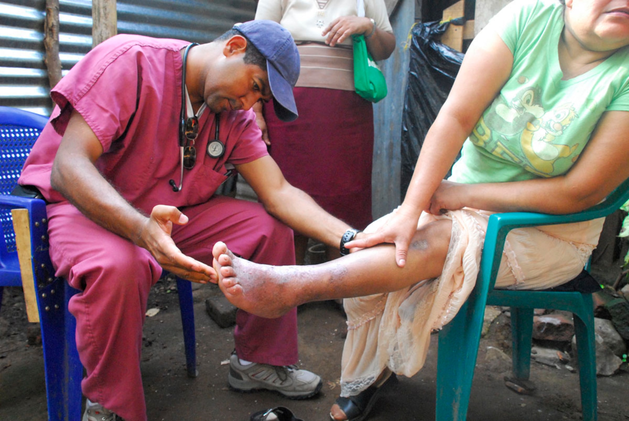 COMASAGUA, El Salvador ? Dr. Miguel Coello, MEDEL liaison officer, examines the leg of a Salvadoran woman at her home May 8. The woman was unable to walk to the school near Comasagua, El Salvador where free medical care was offered during the medical readiness training exercise portion of Fuerzas Aliadas Humanitarias 2008, the U.S. Southern Command and Salvadoran Ministry of Defense-sponsored exercise held throughout the Central American region May 5-15. (U.S. Air Force photo by Tech. Sgt. William Farrow)  