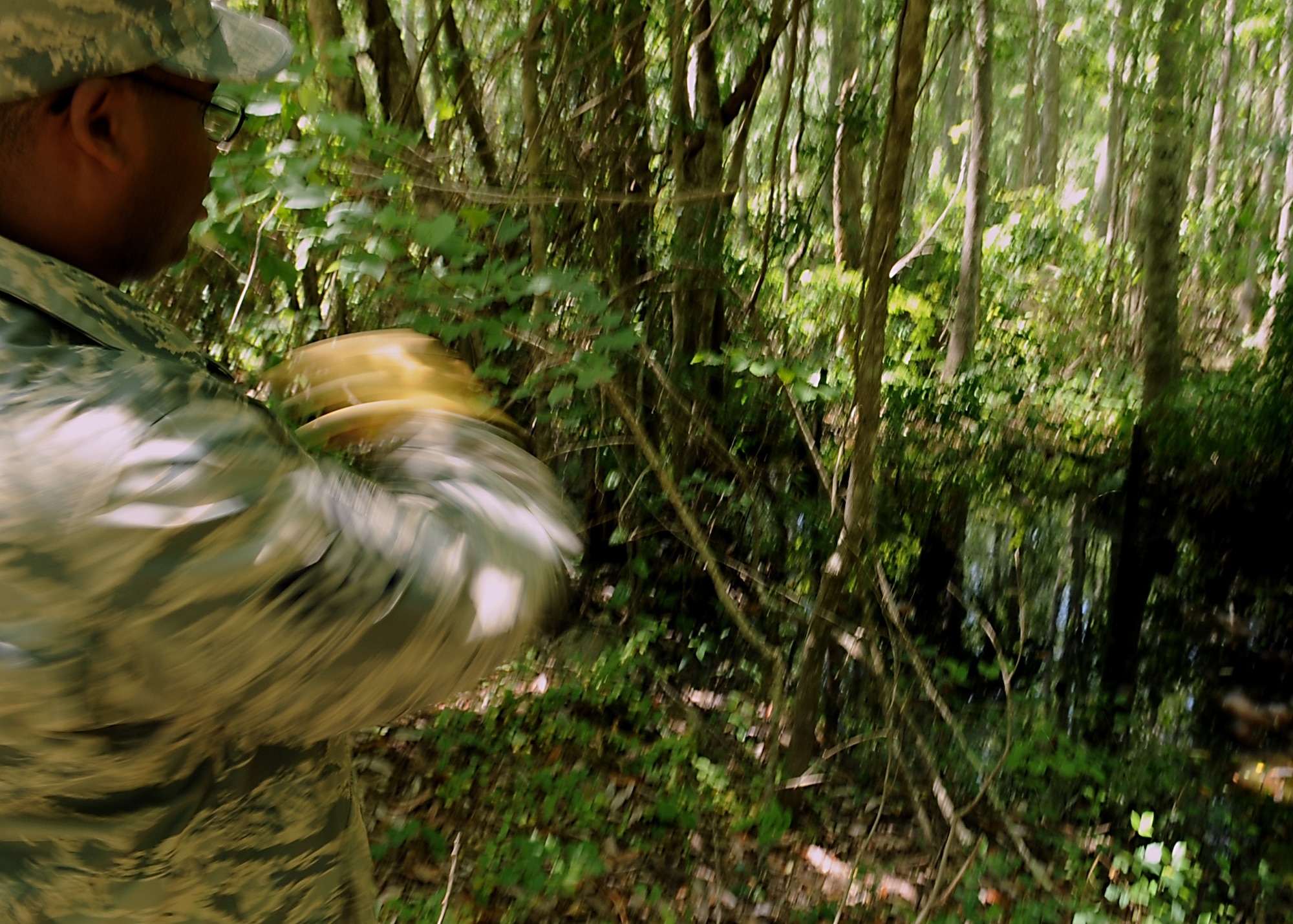 MOODY AIR FORCE BASE, Ga. -- Staff Sgt. Richard Mauldin, 23rd Civil Engineer Squadron entomologist, throws an insecticide briquette into a small pond here May 12. The insecticide briquettes contain bacillus thuringiensis which kills mosquito larvae. (U.S. Air Force photo by Airman 1st Class Brittany Barker)