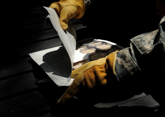 MOODY AIR FORCE BASE, Ga. -- Staff Sgt. Richard Mauldin, 23rd Civil Engineer Squadron entomologist, opens a package of insecticide briquettes here May 12. The insecticide briquettes are thrown into stagnant water or other places mosquitoes breed to kill the larvae. (U.S. Air Force photo by Airman 1st Class Brittany Barker)