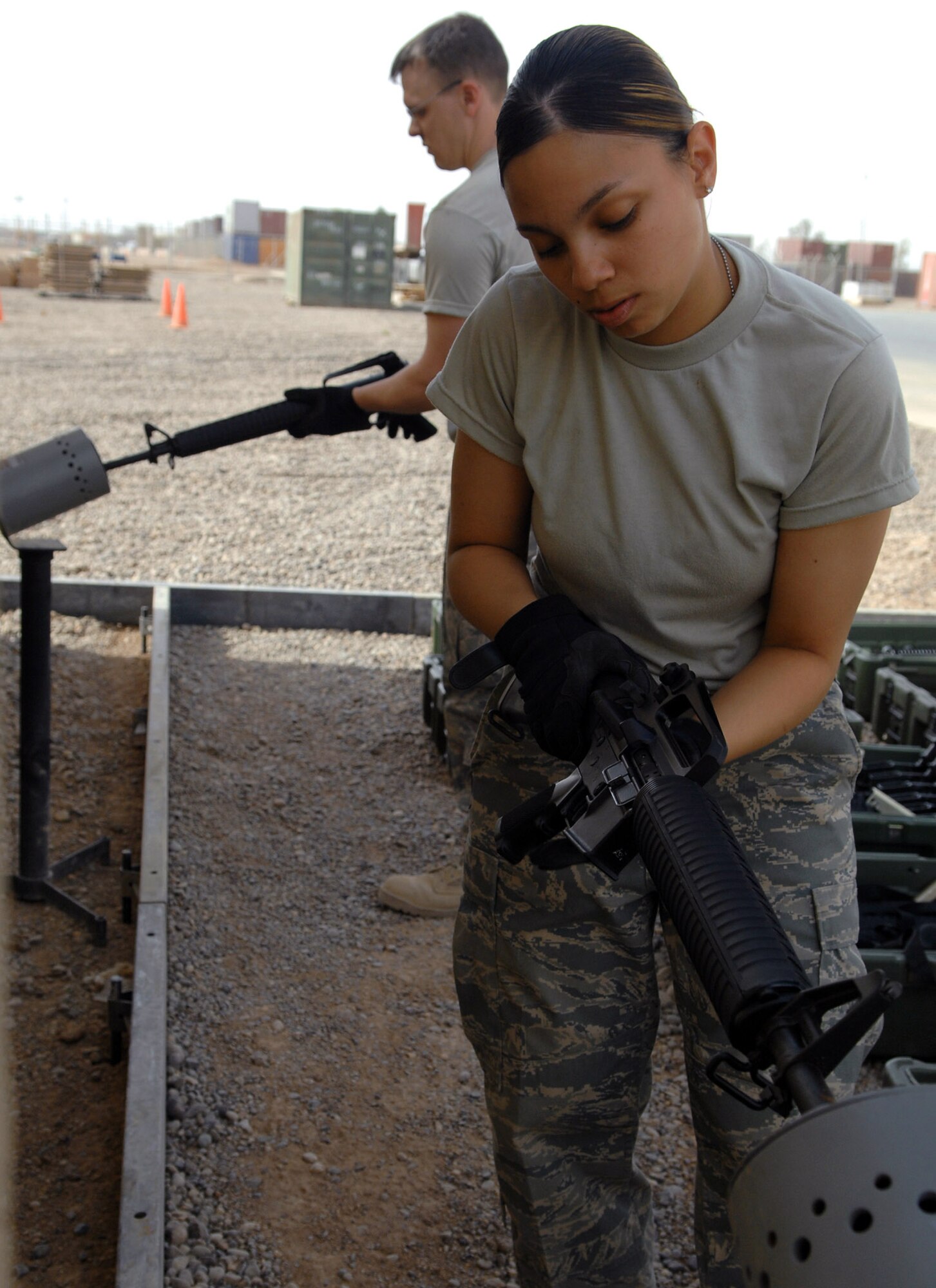 Airman 1st Class Lianette Williams clears an M-16 rifle in a clearing barrel before turning it into the armory April 5 at Balad Air Base, Iraq. Airman Williams is a 332nd Expeditionary Logistics Readiness Squadron base supply manager deployed from Luke Air Force Base, Ariz. (U.S. Air Force photo/Senior Airman Julianne Showalter) 

