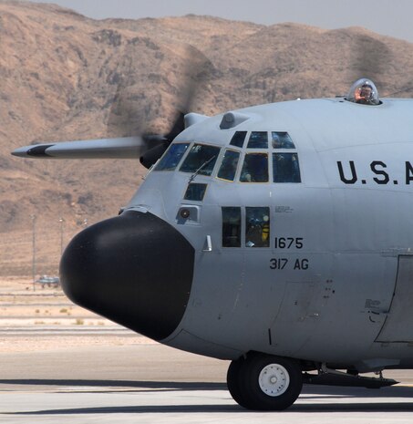 NELLIS AIR FORCE BASE, Nev.—A crew member waves from the observation bubble of a C-130 Hercules while taxing during the U.S. Air Force Weapons School Mobility Air Forces Exercise here May 9. The aircraft and crew are from the 317th Airlift Group at Dyess AFB, Texas. The Weapons School holds MAFEX twice a year to test the ability of C-17A Globemaster III and C-130 Hercules aircrews from 12 Air Force bases around the world to join together in a formation at a specific time and location to insert ground forces anywhere in the world. (U.S. Air Force photo/Chief Master Sgt. Gary Emery)