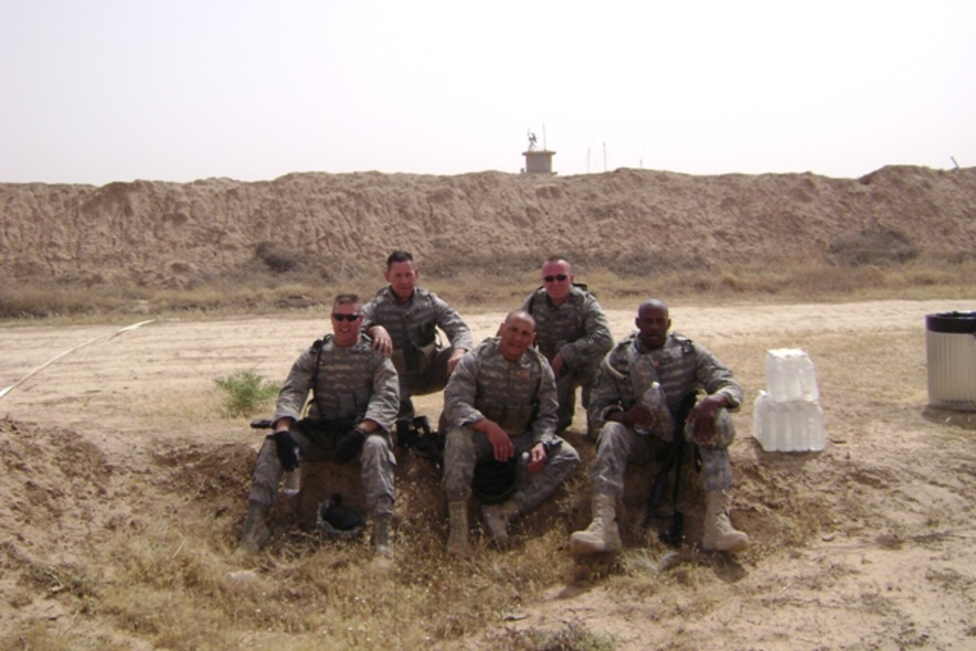 Major Jeffrey Prindle and Master Sgt. Kenneth Lewis, 315 Security Forces Squadron, Charleston Air Force Base, S.C., take a break to rehydrate during the Quick Reaction Force Challenge at Forward Operating Base Warrior, Kirkuk, Iraq. The 20 five-man teams competed in a four-event competition designed to simulate situations a QRF team might encounter in combat. The four events were a one-mile race to the perimeter in full combat gear, a live-fire stress shoot, a quarter-mile casualty litter evacuation and a 500 feet armored vehicle push. (Courtesy photo) 