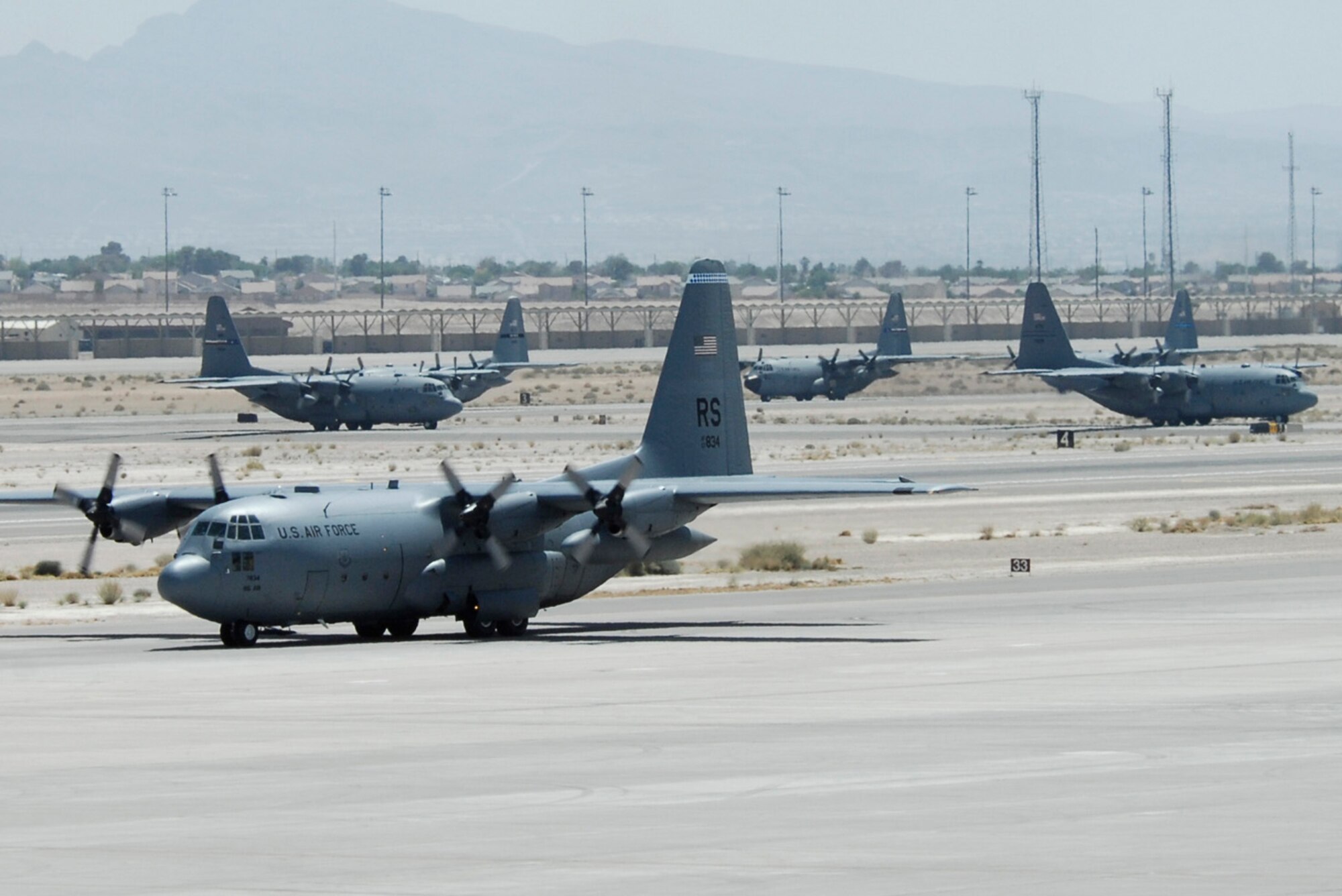 NELLIS AIR FORCE BASE, Nev.--C-130 Hercules’ taxi in formation during the U.S. Air Force Weapons School Mobility Air Forces Exercise here May 9. The Weapons School holds MAFEX twice a year to test the ability of C-17A Globemaster III and C-130 Hercules aircrews from 12 Air Force bases around the world to join together in a formation at a specific time and location to insert ground forces anywhere in the world. (U.S. Air Force photo/Airman Stephanie Rubi)