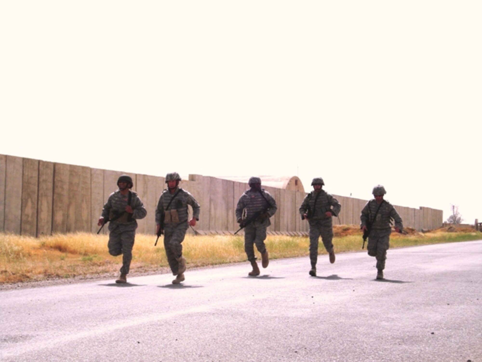 Major Jeffrey Prindle and Master Sgt. Kenneth Lewis, 315 Security Forces Squadron, Charleston Air Force Base, S.C., participate in the five man team one-mile run in full protective gear during the Quick Reaction Force Challenge at Forward Operating Base Warrior, Kirkuk, Iraq. The 20 five-man teams competed in a four-event competition designed to simulate situations a QRF team might encounter in combat. The four events were a one-mile race to the perimeter in full combat gear, a live-fire stress shoot, a quarter-mile casualty litter evacuation and a 500 feet armored vehicle push. (Courtesy photo) 