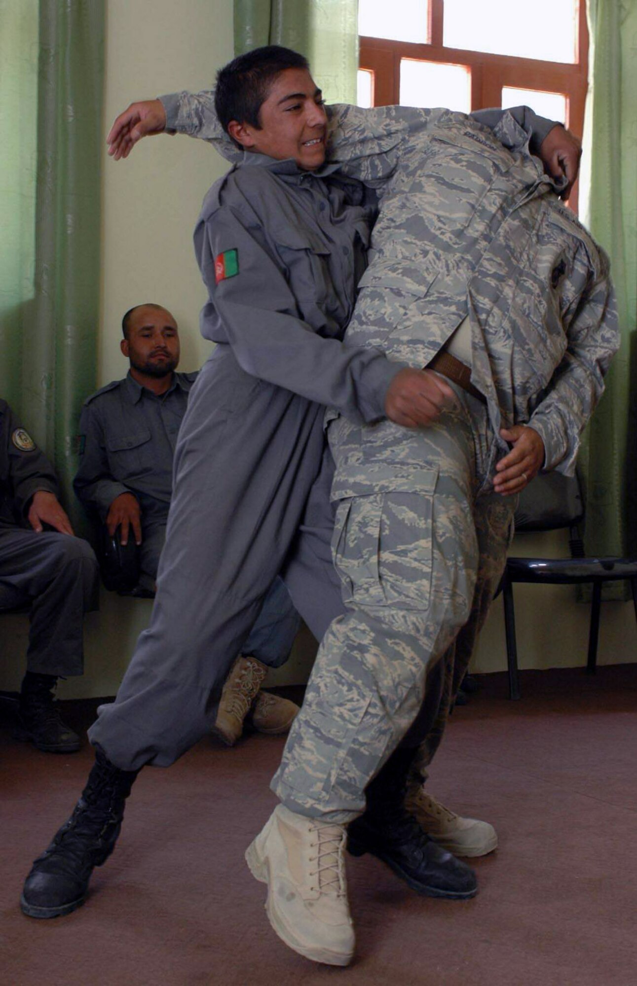An Afghanistan National Police officer executes a restraint technique on Tech. Sgt. Chris Padron May 8 at Dandar village in the Parwan province of Afghanistan. Sergeant Padron and a team of Soldiers and Airmen taught the class as a refresher for the ANP for training they received at their academy. Sergeant Padron is a Provincial Reconstruction Team member deployed from Cannon Air Force Base, N.M. (U.S. Air Force photo)