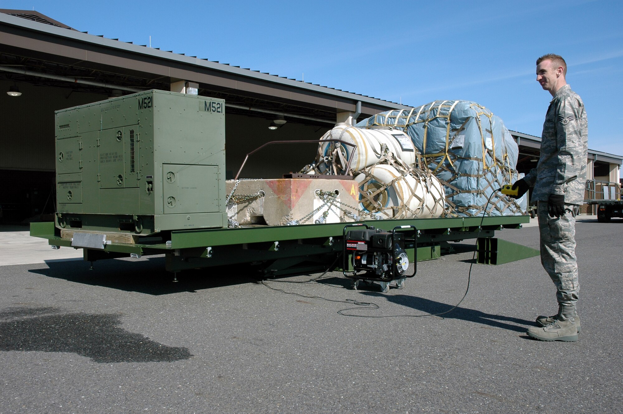An Airman from the 816th Global Mobility Squadron, McGuire Air Force Base, N.J., uses a push-button control to test the lifting of a deployable hydraulic lift as part of a demonstration with the Air Mobility Battlelab April 1, 2008, at McGuire.  The AMB, located in the U.S. Air Force Expeditionary Center on Fort Dix, N.J., coordinated the demonstration as part of the Deployable Hydraulic Lift Initiative which aims to help contingency response Airmen have an easier time moving cargo in deployed locations.  (U.S. Air Force Photo/Art Tollefson)