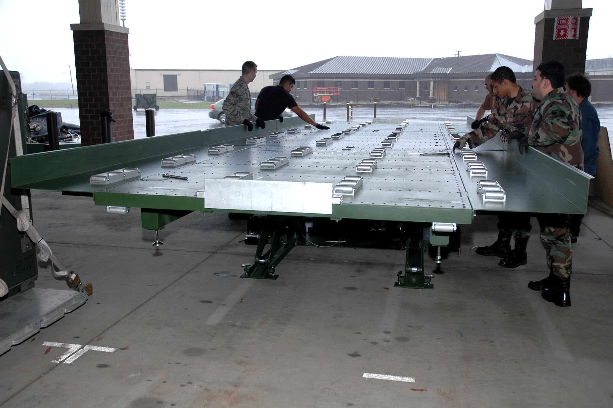Airmen from the 816th Global Mobility Squadron, McGuire Air Force Base, N.J., assemble a deployable hydraulic lift as part of a demonstration for the lift with the Air Mobility Battlelab April 1, 2008, at McGuire.  The AMB, located in the U.S. Air Force Expeditionary Center on Fort Dix, N.J., coordinated the demonstration as part of the Deployable Hydraulic Lift Initiative which aims to help contingency response Airmen have an easier time moving cargo in deployed locations.  (U.S. Air Force Photo/Art Tollefson)