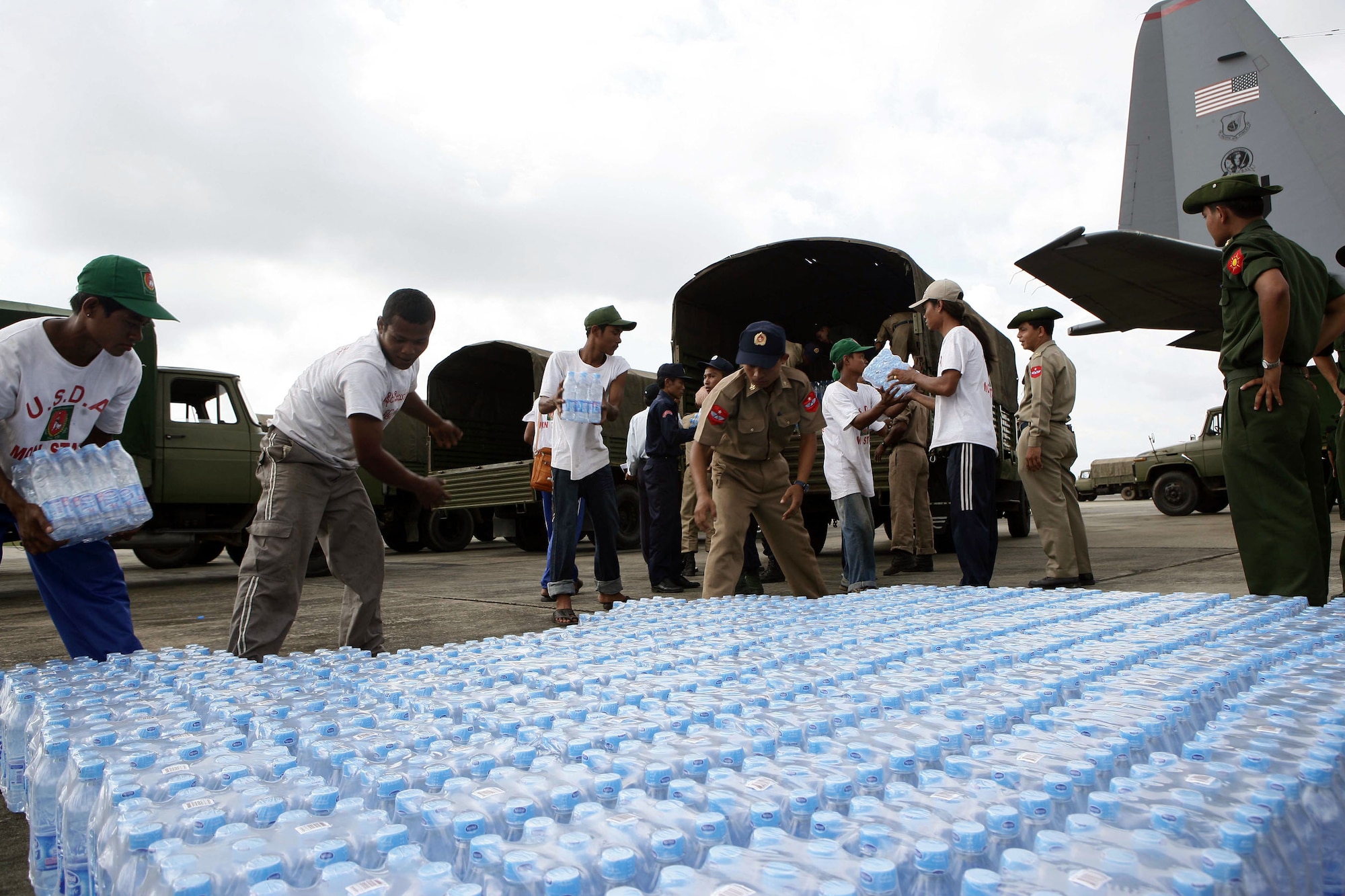 Burman servicemembers and civilian aid workers stage and count the water offloaded from a U.S. Air Force C-130 Hercules May 12 at the Yangon International Airport . The plane carrying water, food and medical supplies provided relief to Burma, which was struck by Cyclone Nargis May 2. (U.S. Marine Corps photo/Sgt. Andres Alcaraz)