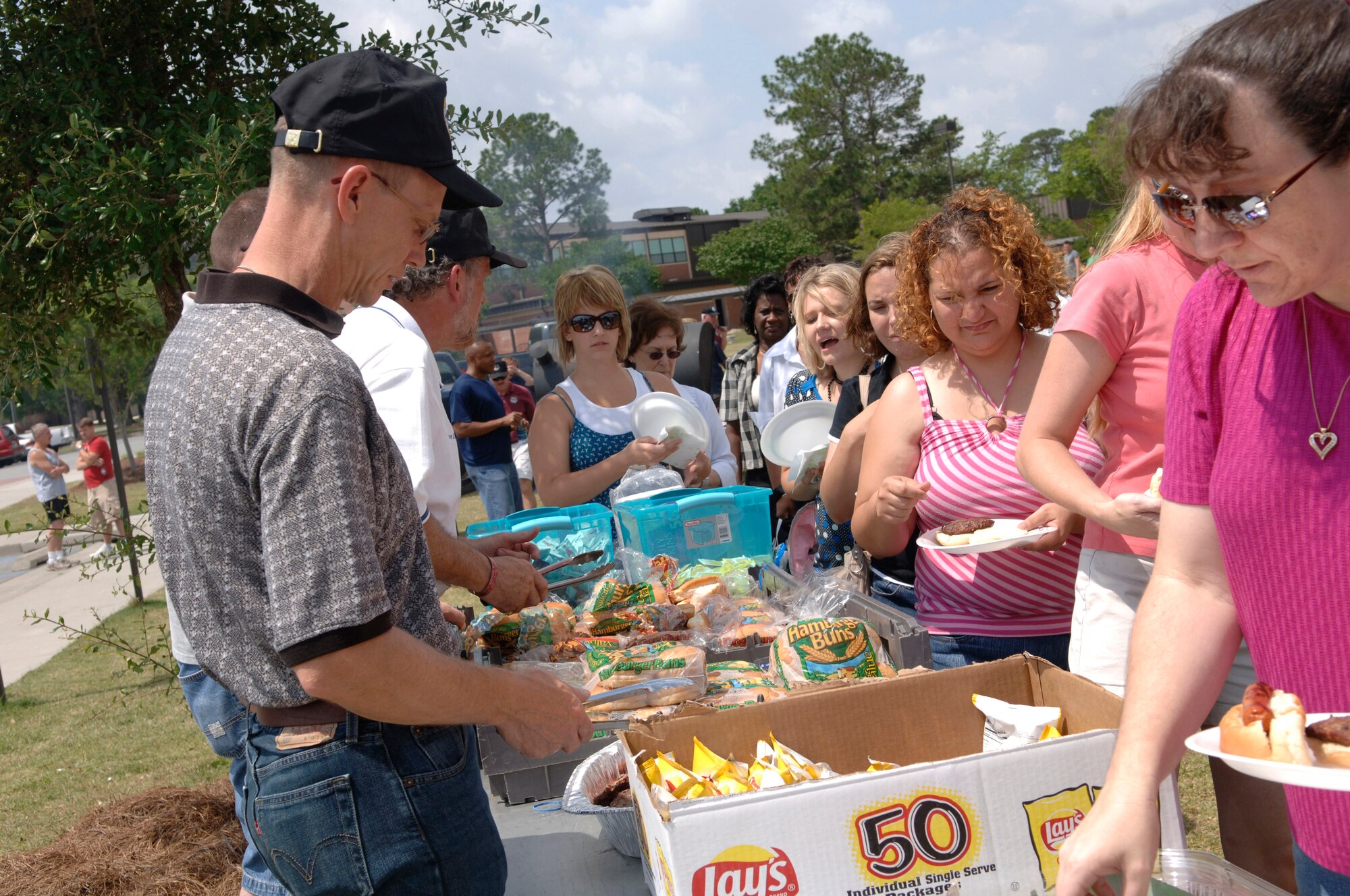 MOODY AIR FORCE BASE, Ga - - Participants at Moody Air Force Base's Spouse’s Appreciation Day enjoy free burgers and hot dogs provided for the event here May 9. The event included aircraft displays, a firearms training simulator, A-10C flight simulator, and free 10-minute aqua massages. (U.S Air Force photo by Senior Airman Schelli Jones)