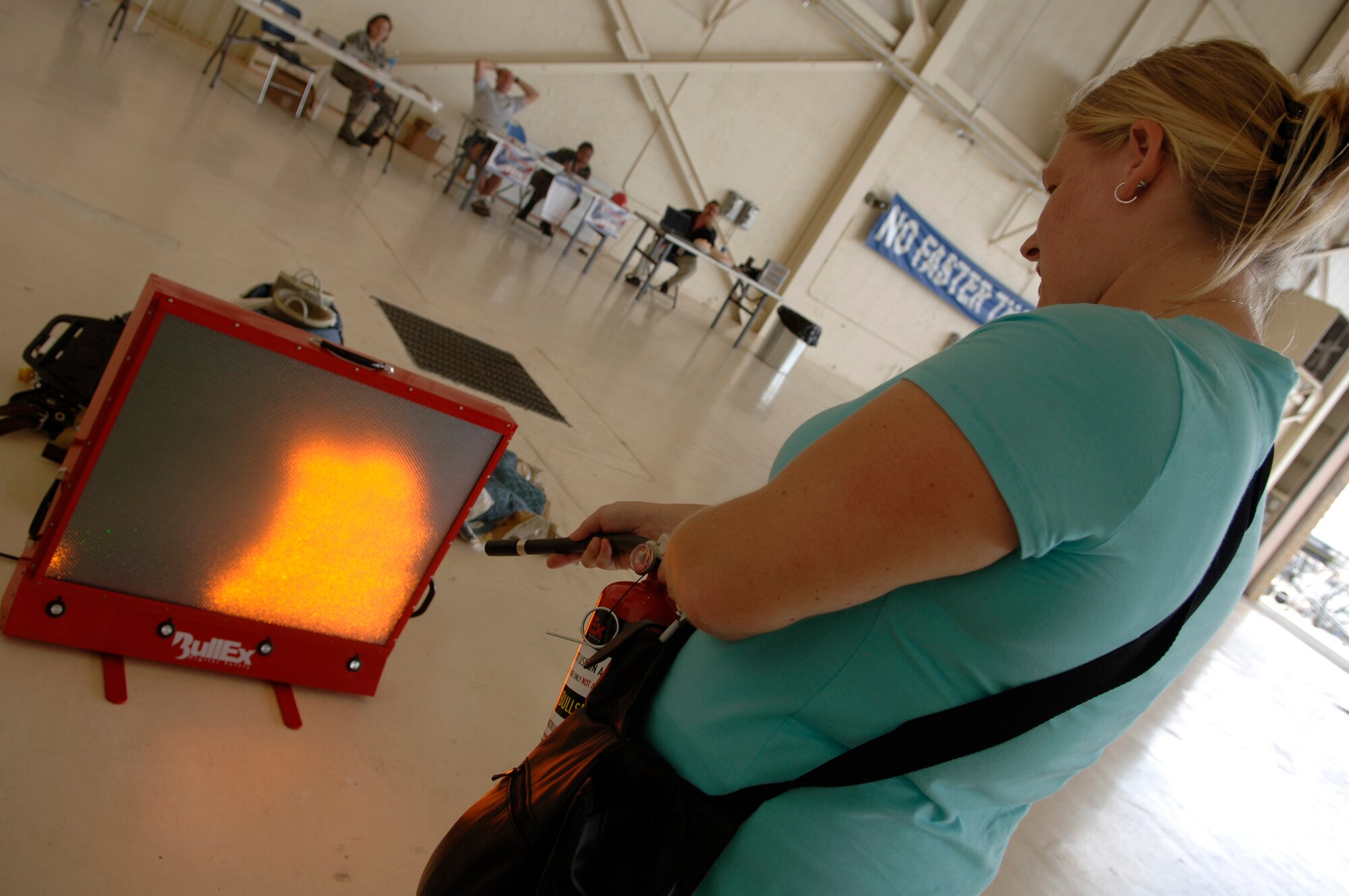 MOODY AIR FORCE BASE, Ga - - Heather Drocea, wife of Staff Sgt. Thomas Drocea, 23rd Aircraft Maintenance Squadron A-10C electrical and environmental technician, practices with a fire extinguisher trainer during Spouse's Day here May 9. (U.S Air Force photo by Senior Airman Schelli Jones)

