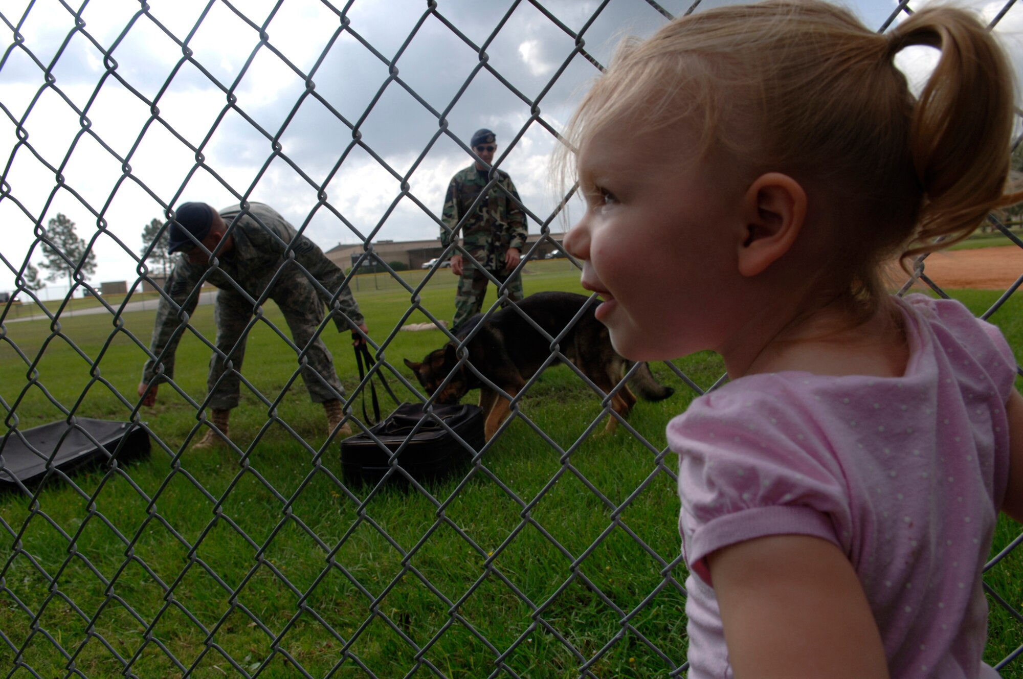 MOODY AIR FORCE BASE, Ga - - Ariel Cline, daughter of Airman 1st Class Daniel Cline, 824th Security Forces Squadron fire team member, smiles while watching demonstration given by the 23rd Security Forces Squadron military working dog handlers here May 9.  (U.S Air Force photo by Senior Airman Schelli Jones)