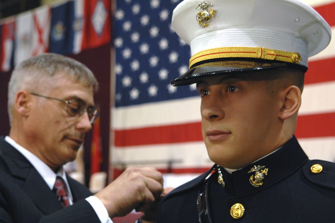Steven Mason pins gold bars on his son, U.S. Marine 2nd Lt. Matthew Mason, during the Norwich University graduation ceremony in Northfield, Vt., May 10, 2008.