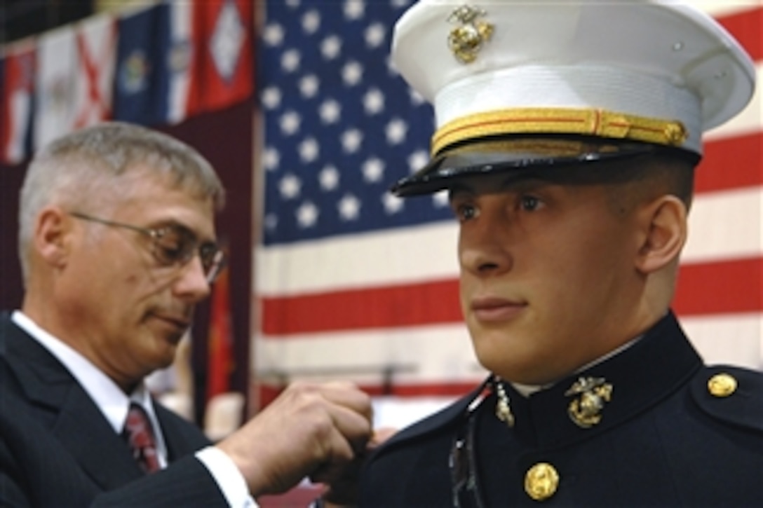 Steven Mason pins gold bars on his son, U.S. Marine 2nd Lt. Matthew Mason, during the Norwich University graduation ceremony in Northfield, Vt., May 10, 2008. U.S. Vice Chairman of the Joint Chiefs of Staff Marine Gen. James Cartwright administered the oath of office to more than 100 newly commissioned officers. 