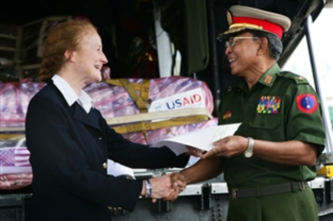 Henrietta H. Fore, left, administrator, U.S. Agency for International Development, greets an official at the Yangon International Airport, Rangoon, Burma, May 12, 2008. The plane carrying water, food and medical supplies is to provide relief to Burma which was struck by Cyclone Nargis on May 2, 2008.