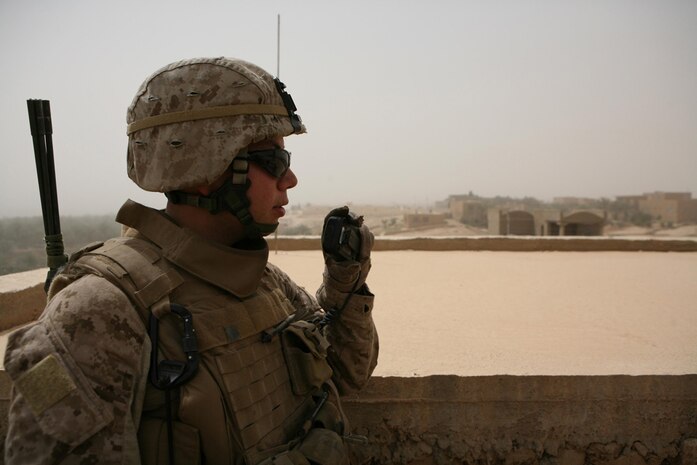 Lance Cpl. Christopher A. Ramirez, 22, rifleman with Company K, 3rd Battalion, 4th Marine Regiment, Regimental Combat Team 5, from Los Angeles, radios in his squadâ??s position during a patrol in Haditha, Iraq, May 13. Marines with 3rd Bn., 4th Marines, conduct security patrols throughout the city to ensure the safety of locals. Marines also integrate Iraqi policemen into their patrols as much as possible to show the community that both forces are working together.