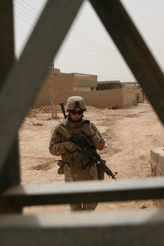 Lance Cpl. Christopher A. Ramirez, 22, a rifleman with Company K, 3rd Battalion, 4th Marine Regiment, Regimental Combat Team 5, from Los Angeles, talks into his radio during a security patrol through Haditha, Iraq, May 13. Marines with Company K patrolled through the city with an Iraqi policeman integrated into the patrol. Marines have been doing everything they can to assist Iraqi Police in improving their skills.
