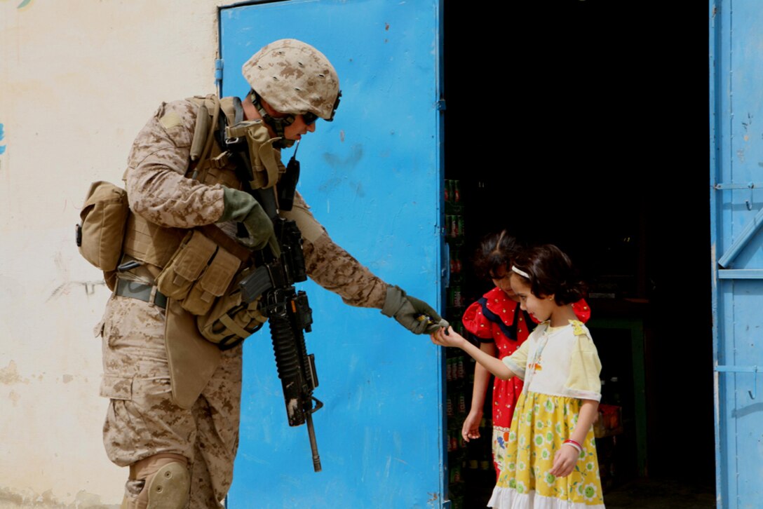 Cpl. James W. Blacker, 23, from San Diego, gives candy to Iraqi girls during a security patrol May 13. Blacker is a team leader with Company K, 3rd Battalion, 4th Marine Regiment, Regimental Combat Team 5. The company patrolled the city with an Iraqi policeman to show the locals that Marines are still active in keeping the city secure as the Iraqi police force continues making strides.