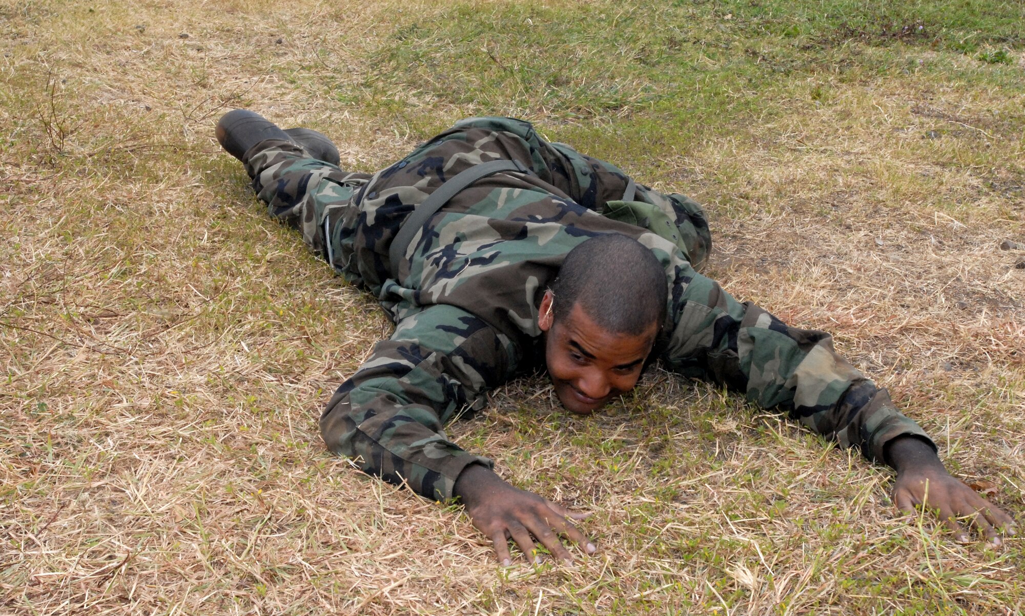 Staff Sgt. Krystopher Douglas, 15th Aircraft Maintenance Squadron, low crawls during the Hickam Ability to Survive and Operate portion of an exercise here. The exercise is in preparation for the upcoming Operational Readiness Inspection. (U.S. Air Force Photo/Senior Master Sgt. Russell Dodson.)