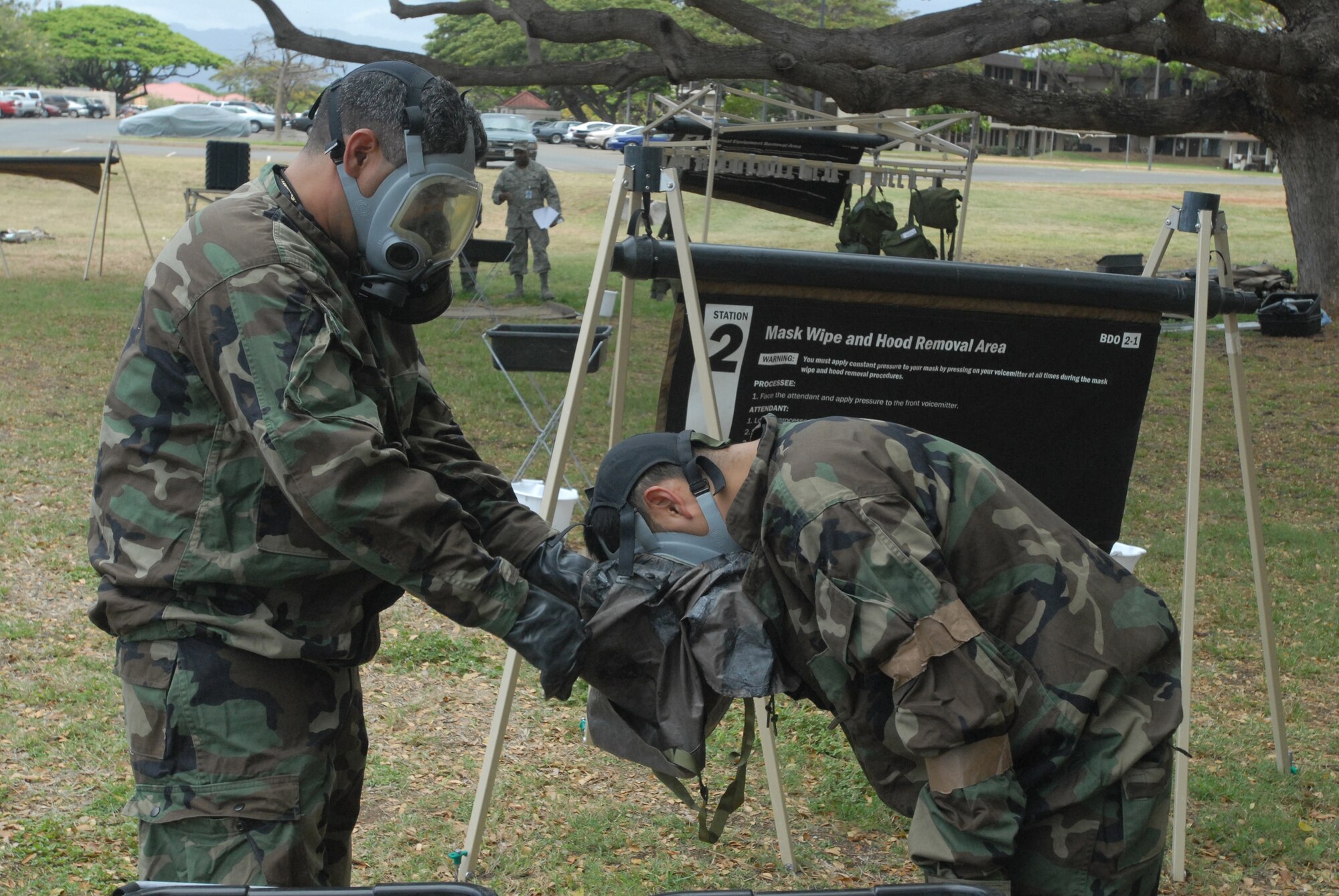 Hickam Airmen use the buddy system to help one another through the contamination control area during during the Ability To Survive and Operate portion of an exercise here. The exercise is in preparation for the upcoming Operational Readiness Inspection. (U.S. Air Force Photo/Senior Master Sgt. Russell Dodson.)