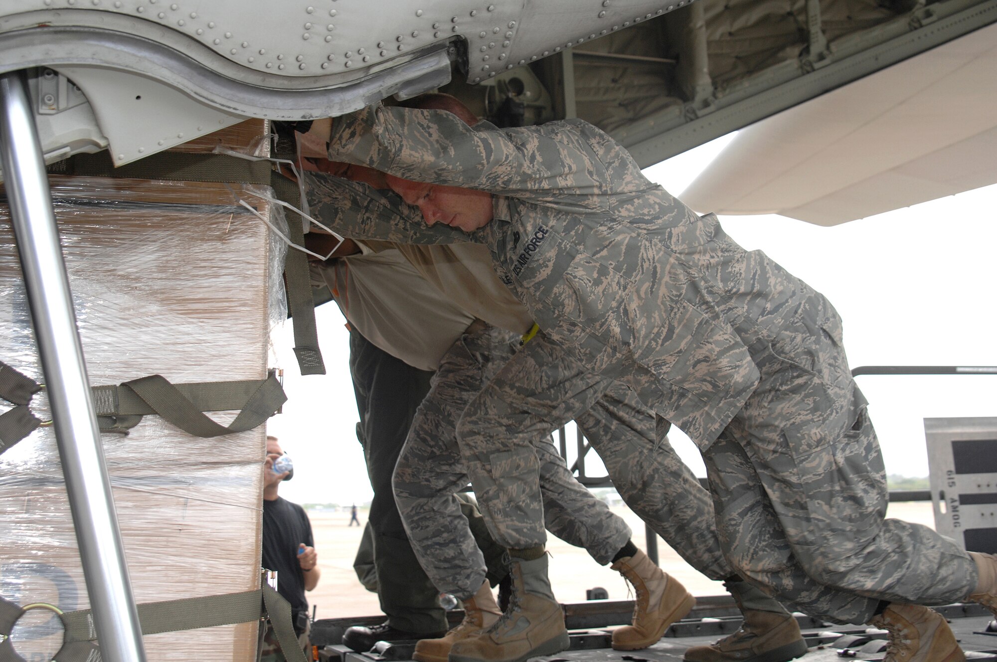Airmen from Andersen AFB, Guam in support of humanitarian relief efforts, load a U.S. Marine Corps C-130 with 1,500 pounds of plastic tarp, 800 blankets and 12,250 pounds of water to Burma from Utapao International Airport. (U.S. Air Force photo by Senior Airman Sonya Croston)