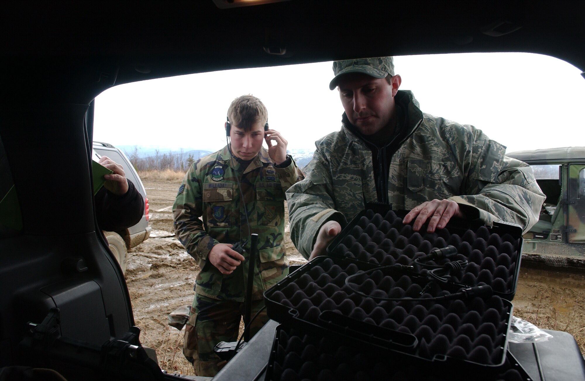 Senior Airman Nicholas Halladay tries out new cocom-x communication equipment, which is one device that takes the place of three different radio systems, while Gregory Burnett gathers more equipment for testing May 5, 2008, at Eielson Air Force Base, Alaska during Northern Edge 08 exercise. Tactical Air Control Party Airmen are helping test new experimental equipment in the field. After several tests, they are providing feedback on how the equipment worked if any improvements could be made before the equipment will be used in combat situations years from now. Northern Edge is a joint training exercise hosted by Alaskan Command and is one of a series of U.S. Pacific Command exercises that prepare joint forces to respond to crises in the Asian Pacific region. Airman Halladay is a TACP assigned to Detachment 1, 3rd Air Support Operation Squadron from Fort Richardson, Alaska. Mr. Burnett is an Air Force Civilian from Wright-Patterson Air Force Base. (U.S. Air Force Photo/Airman 1st Class Jonathan Snyder)