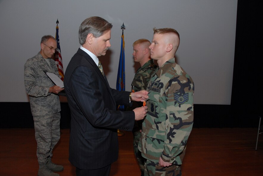 North Dakota Governor John Hoeven pins the Air Force Combat Action Medal on Staff Sgt. Aaron D. Giere, 119th Detachment 2, at a ceremony here, May 13.  Master Sgt. Dominic A. Cook, 119th Det. 2, is also presented the AFCAM by Gov. Hoeven who is assisted by Brig. Gen. Patrick L. Martin, North Dakota National Guard assistant adjutant general for air.   Sergeants Giere and Cook received the medal in recognition of actively participating in combat operations while serving in Iraq in 2003. The AFCAM has only been awarded to two other members in the history of the N.D. ANG; Sergeants Cook and Giere are the first to receive it for the ANG Detachment in Minot. (U.S. Air Force photo by Senior Master Sgt. David H. Lipp) 