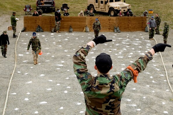 Blindfolded competitors navigate the minefield challenge using third-party vocal cues to stay on course. Senior Airman Eric Camacho, 62nd Aircraft Maintenance Squadron, uses hand signals to guide his spotter teammates, who then give the verbal cues. (Photos by Abner Guzman.)