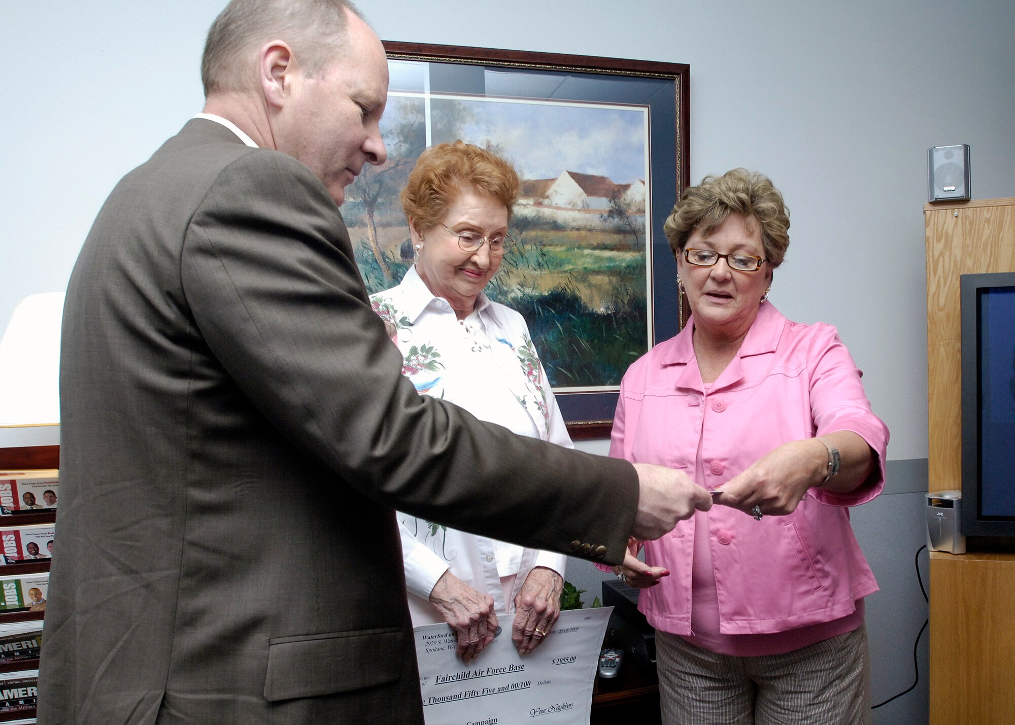 FAIRCHILD AIR FORCE BASE, Wash. – Jeffrey Bair, Waterford community executive director, presents Linda Miles, Airman & Family Readiness Center, with a check for $1,055. The money is a donation toward the Call Home Campaign, and will be used to help purchase calling cards for deployed military members. (U.S. Air Force photo/Senior Airman Eunique Stevens)