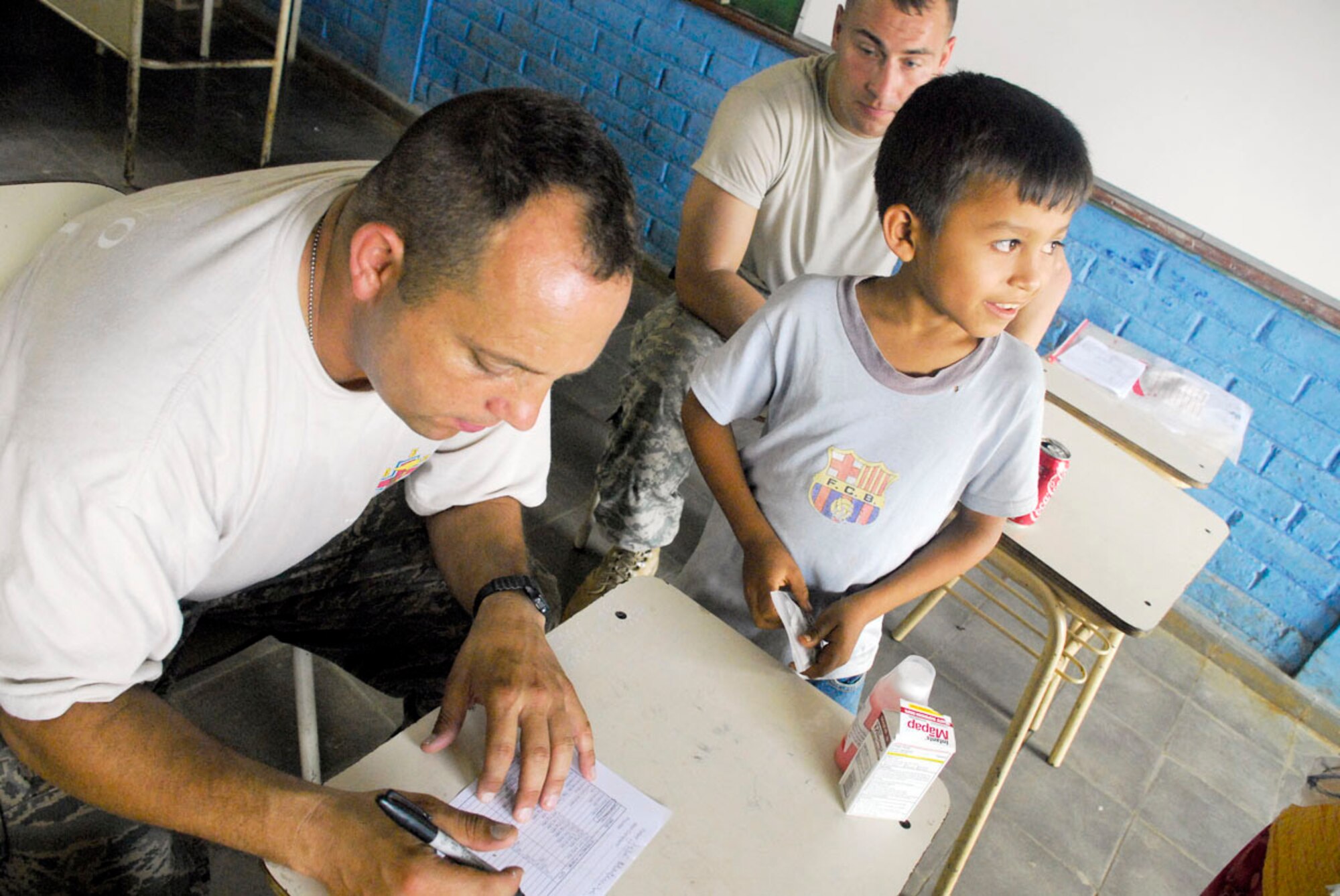 Capt. Manny Silviera reviews a prescription for a Salvadoran boy May 8 at a make-shift pharmacy in a school at Comasagua, El Salvador. Medical aid was provided during Fuerzas Aliadas Humanitarias 2008, the U.S. Southern Command and Salvadoran Ministry of Defense-sponsored exercise held throughout the Central American region May 5 to 15. During the exercise, medication valued at more than $10,000 was dispensed to Salvadorans in need. (U.S. Air Force photo/Tech. Sgt. William Farrow)