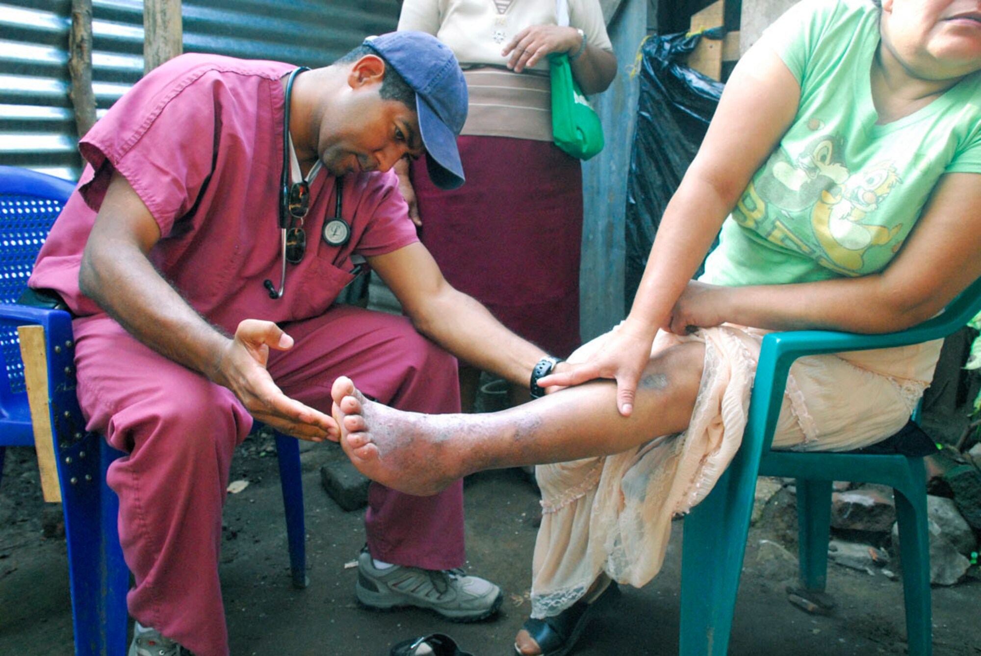 Dr. Miguel Coello examines the leg of a Salvadoran woman at her home May 8. The woman  was unable to walk to the school near Comasagua, El Salvador, where free medical care was offered during the medical readiness training exercise portion of Fuerzas Aliadas Humanitarias 2008, the U.S. Southern Command and Salvadoran Ministry of Defense-sponsored exercise held throughout the Central American region May 5 to 15. Dr. Coello is Joint Task Force-Bravo's Medical Element liaison officer. (U.S. Air Force photo/Tech. Sgt. William Farrow) 