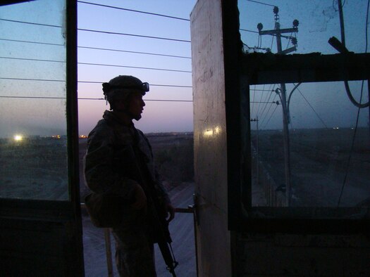 Airman 1st Class Broch Travis, Multi-National Force-West intelligence operations specialist, stands on perimeter guard duty in Camp Fallujah, Iraq. Airman Travis is currently deployed from the 509th Operations Support Squadron at Whiteman Air Force Base, Mo., to an "in-lieu-of" position with members of the Marines, Navy and Army. (U.S. Air Force Courtey Photo)                