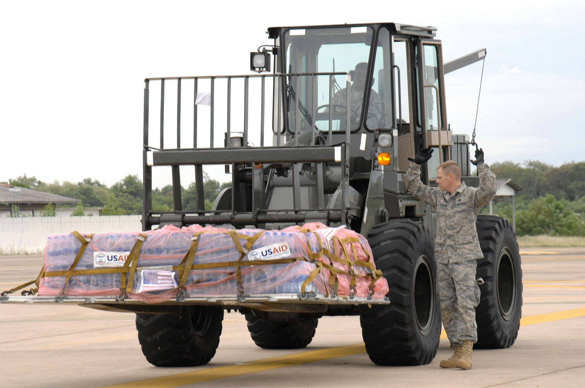 Master Sgts. Todd Kneisly and Don Gambles transport a pallet of bottled water weighing in at approximately 4,000 pounds to a C-130 Hercules for humanitarian relief to victims of Burma May 12 at Utapao Air Base, Thailand. Approximately 45 servicemembers from Andersen Air Force Base, Guam, arrived in Thailand May 8 to offer their assistance with a water purification unit and two airfield opening/operating teams. Sergeant Kneisly and Gambles are assigned to the 36th Mission Response Squadron from Andersen AFB. (U.S. Air Force photo/Senior Airman Sonya Croston) 
