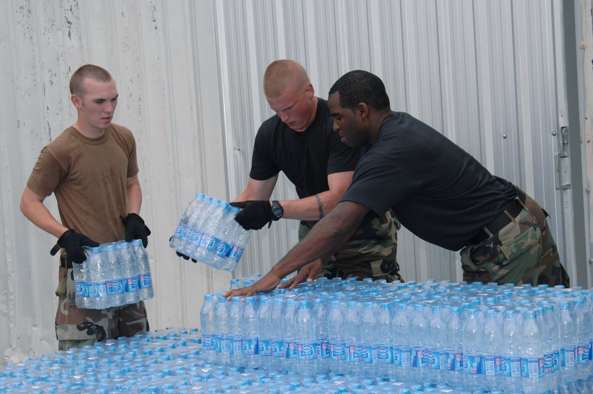 Senior Airman Shaun Rhine, Staff Sgt. Shaun Kegin and Tech. Sgt. Andree Curlee package bottled water in support of humanitarian relief efforts for the victims of Cyclone Nargis in Burma May 11 at Utapao Air Base, Thailand. Approximately 45 servicemembers from Andersen Air Force Base, Guam, arrived in Thailand May 8 to offer their assistance with a water purification unit and two airfield opening/operating teams. Airman Rhine and Sergeant Kegin and Curlee are assigned to the 36th Contingency Response Group from Andersen AFB. (U.S. Air Force photo/Senior Airman Sonya Croston)

