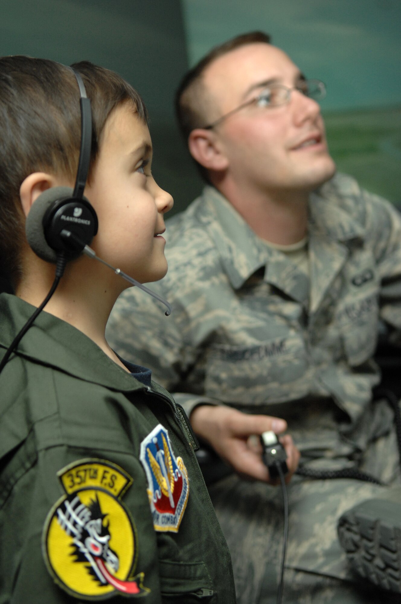 Senior Airman Chris Prudhomme, 355th Operations Support Squadron Air Traffic Controller, helps Connor Riordan, age 5, use an air traffic control simulator during his visit to D-M, May 9. Connor participated in the Pilot for a Day program designed to give local children with illnesses an enjoyable day completely devoted to them and their interest in aviation. (U.S. Air Force photo/Airman 1st Class Noah R. Johnson)