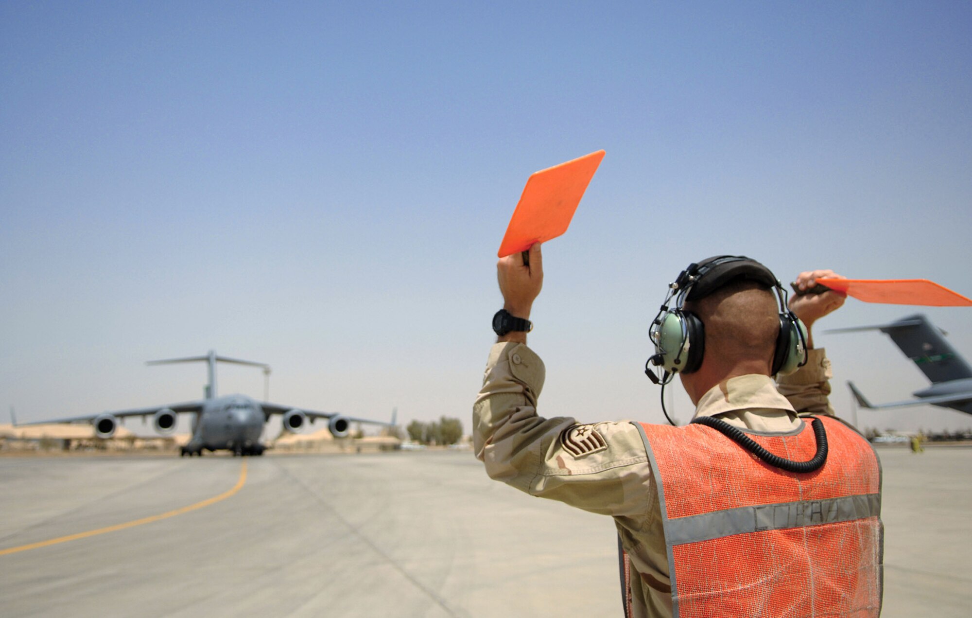 Tech. Sgt. Frank Wisnieski  marshals in a C-17 Globemaster III May 12 at Balad Air Base, Iraq. Directing an aircraft into an appropriate parking location is crucial to ensuring safe airfield operations and enables flightline personnel to execute their duties. Sergeant Wisnieski is a 332nd Expeditionary Maintenance Squadron transient alert supervisor deployed from Ramstein Air Base, Germany. (U.S. Air Force photo/Senior Airman Julianne Showalter) 
