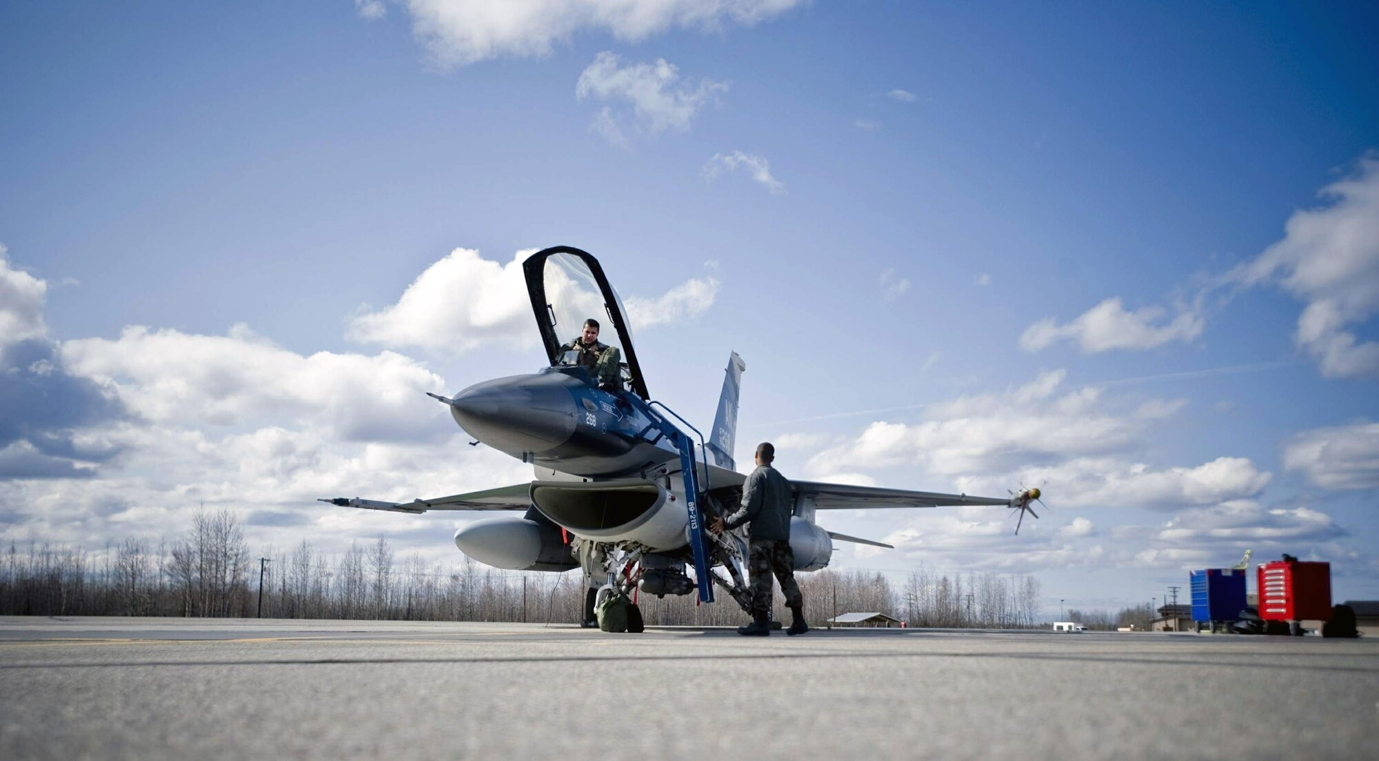 Airman 1st Class Kyle Hughes attaches a ladder to an 18th Aggressor Squadron F-16 Fighting Falcon May 8 at Eielson Air Force Base, Alaska. The 18th Aggressor Squadron is participating in Northern Edge 2008. The squadron is under 24-hour operations, ensuring all aircraft are at full operability for flight during the exercise. Airman Hughes is a 354th Aircraft Maintenance Squadron crew chief. (U.S. Air Force photo/Airman 1st Class Jonathan Steffen) 