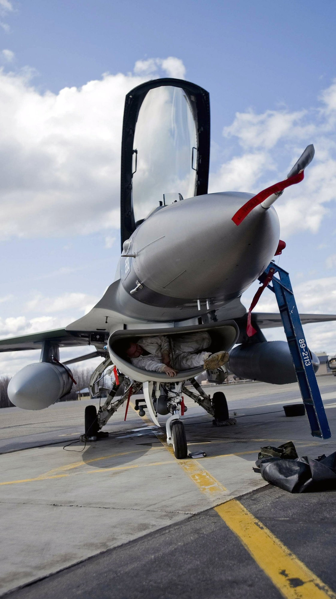 Staff Sgt. Dustin Stewart crawls out of an F-16 Fighting Falcon intake after checking the fan blades for wear and tear May 8 at Eielson Air Force Base, Alaska. The aircraft belongs to the 18th Aggressor Squadron and is participating in Northern Edge 2008. Sergeant Stewart is a member of the 354th Aircraft Maintenance Squadron. (U.S. Air Force photo/Airman 1st Class Jonathan Steffen) 