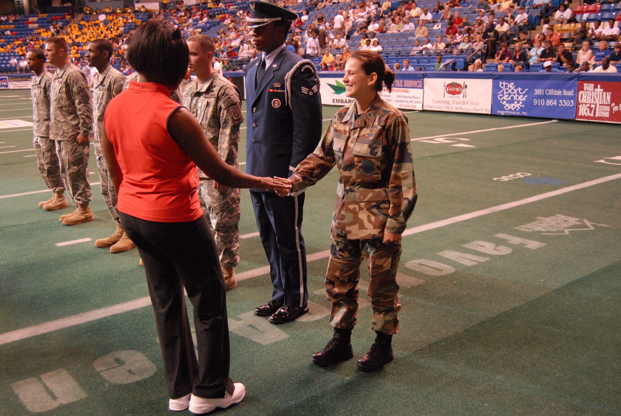 Val Applewhite, Fayetteville City Council member, presents an Operation Welcome Home coin to 1st Lt. Kelly Stuart, 43rd Operations Support Squadronm, during the Fayetteville Guard's Operation Welcome Home game May 10. (U.S. Air Force Photo by 2nd Lt. Chris Hoyler)