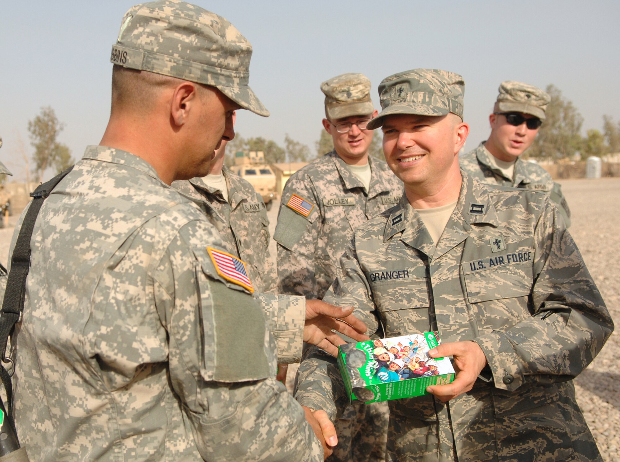BALAD AIR BASE, Iraq -- Air Force Chaplain (Capt.) Jeffrey Granger, 332nd Air Expeditionary Wing, hands out Girl Scout cookies to Soldiers from the 16th of the 38th Truck Company about to embark on a convoy here, May 12. Girl Scouts from Eastern Massachusetts recently donated 1,500 boxes of cookies to the Balad AB in honor of the sacrifices made by servicemembers. Chaplains provide various religious services and materials to deployed personnel to fulfill their spiritual needs; chaplains can also help bolster morale among servicemembers. Captain Granger is deployed from Ellsworth Air Force Base, S.D. (U.S. Air Force photo/ Senior Airman Julianne Showalter)