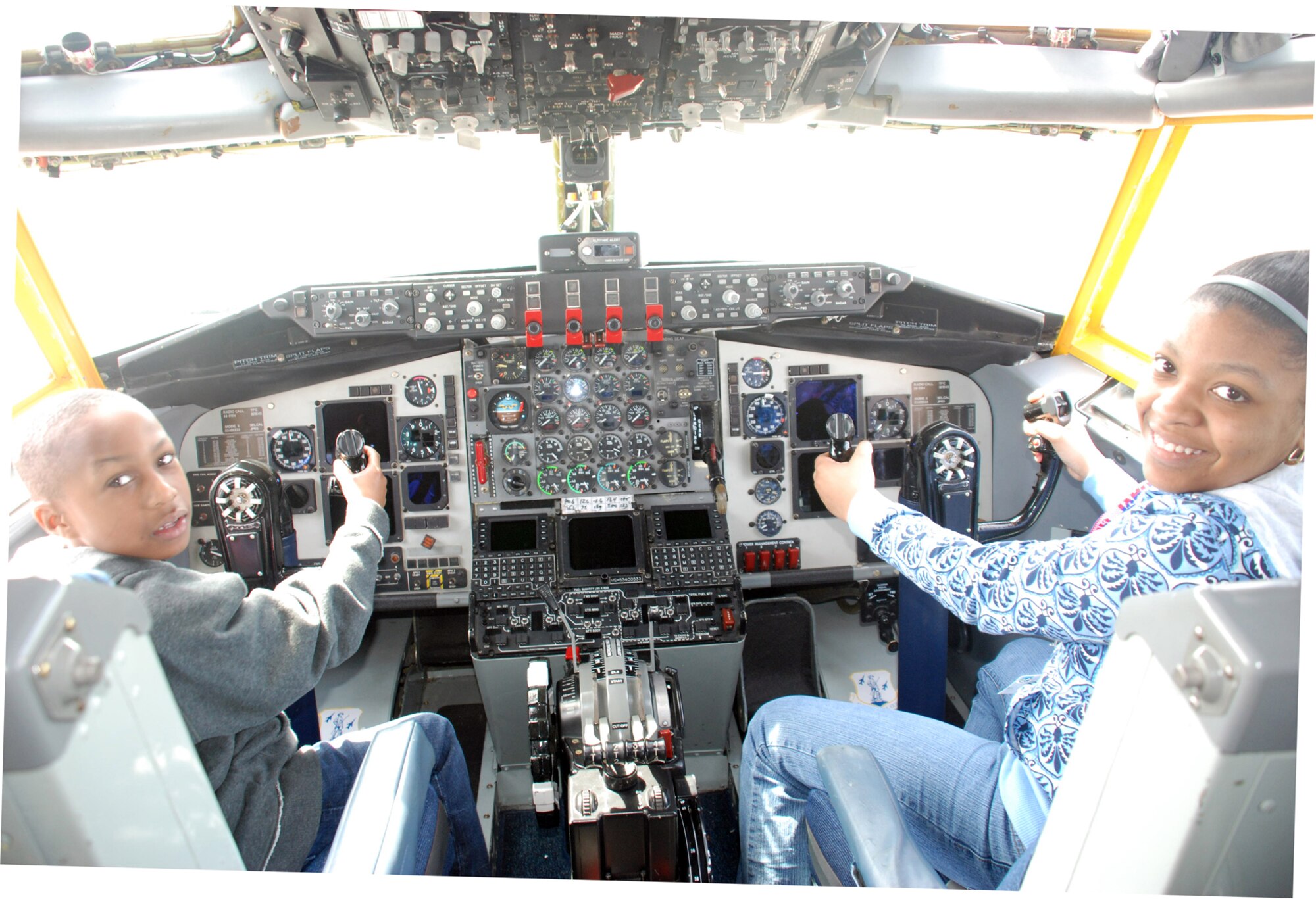 Malia Cox, 12, daughter of Tech Sgt. Kevin Cox, 107th Airlift Wing, and Cortez Bradberry, 8, Malia?s cousin,  pretend to be pilot and co-pilot on a KC-135R during a tour of the aircraft on the 107th?s bring your kids to work day April 24.  