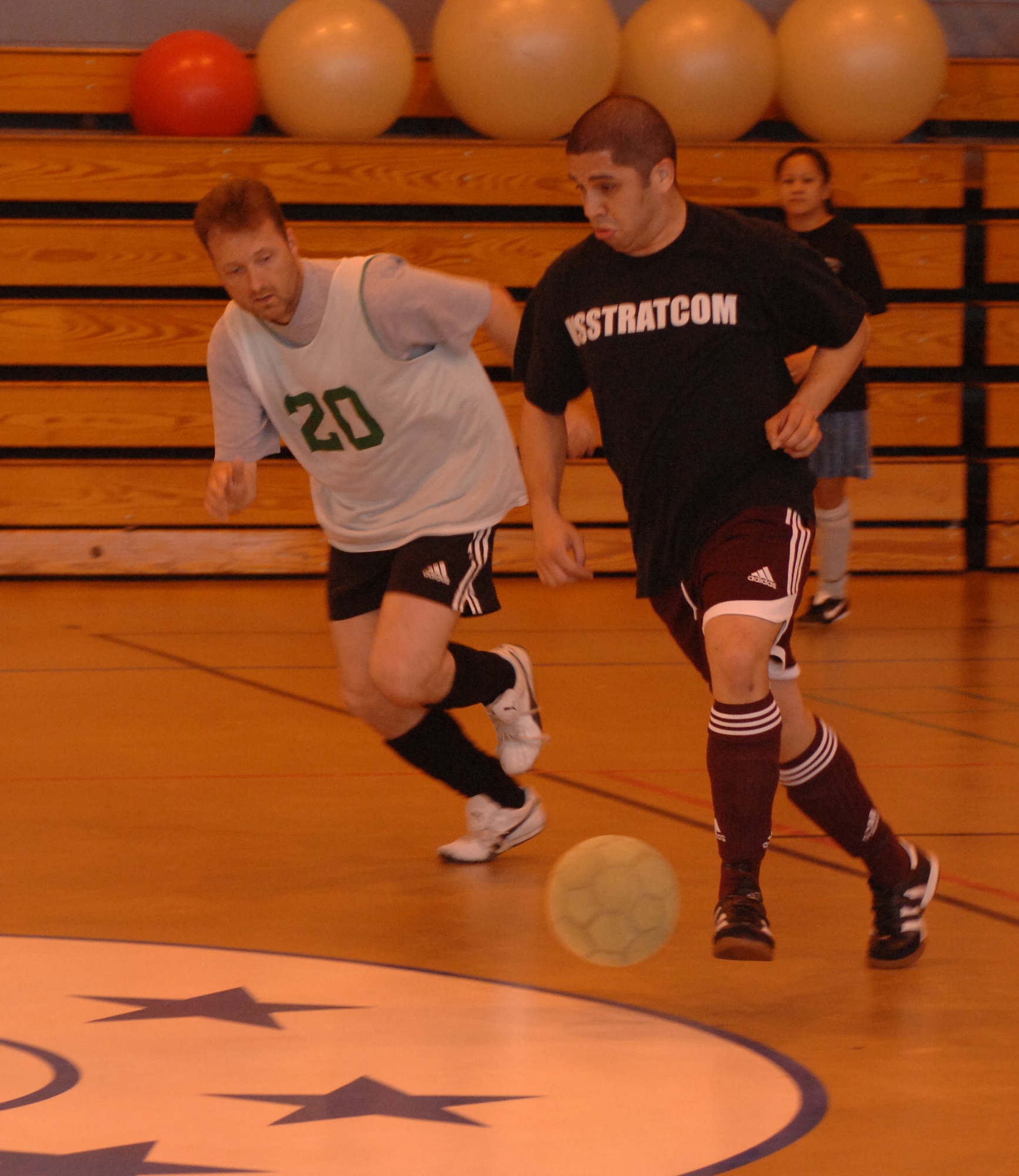The 100th ARW/JA coach, Greg Posada, turns away from Steve Bain (20) to set up another attack. JA won the indoor soccer championship 5-3 over reigning champs 100th CES. (U.S. Air Force photo by Airman 1st Class Brad Smith) 