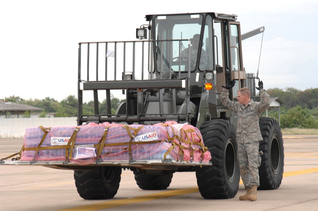 UTAPAO, Thailand - Master Sgts. Todd Kneisly and Don Gambles, 36th Mission Response Squadron, transport a pallet of bottled water weighing in at approximately 4000 lbs to a C-130 Hercules for humanitarian relief to victims of Burma May 12. Approximately 45 well trained and highly motivated members from Andersen AFB arrived in Thailand on May 8 prepared to provide a water purification unit and two airfield opening/operating systems. (USAF Photo/Senior Airman Sonya Croston)