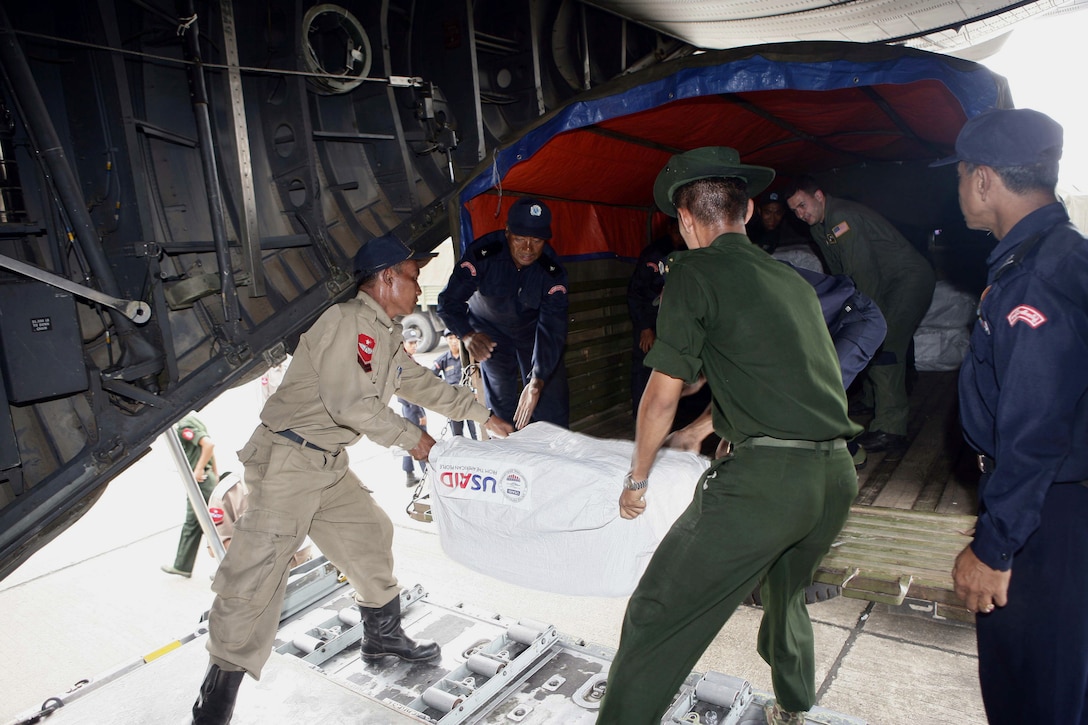 Burmese servicemembers unload food packages from a U.S. Air Force C-130 Hercules to a Burmese military vehicle at the Yangon International Airport, May 12, 2008. The plane carrying water, food and medical supplies is part of the Joint Task Force Caring Response, a multiservice humanitarian assistance and disaster relief effort for Burmese citizens devastated by Cyclone Nargis.  